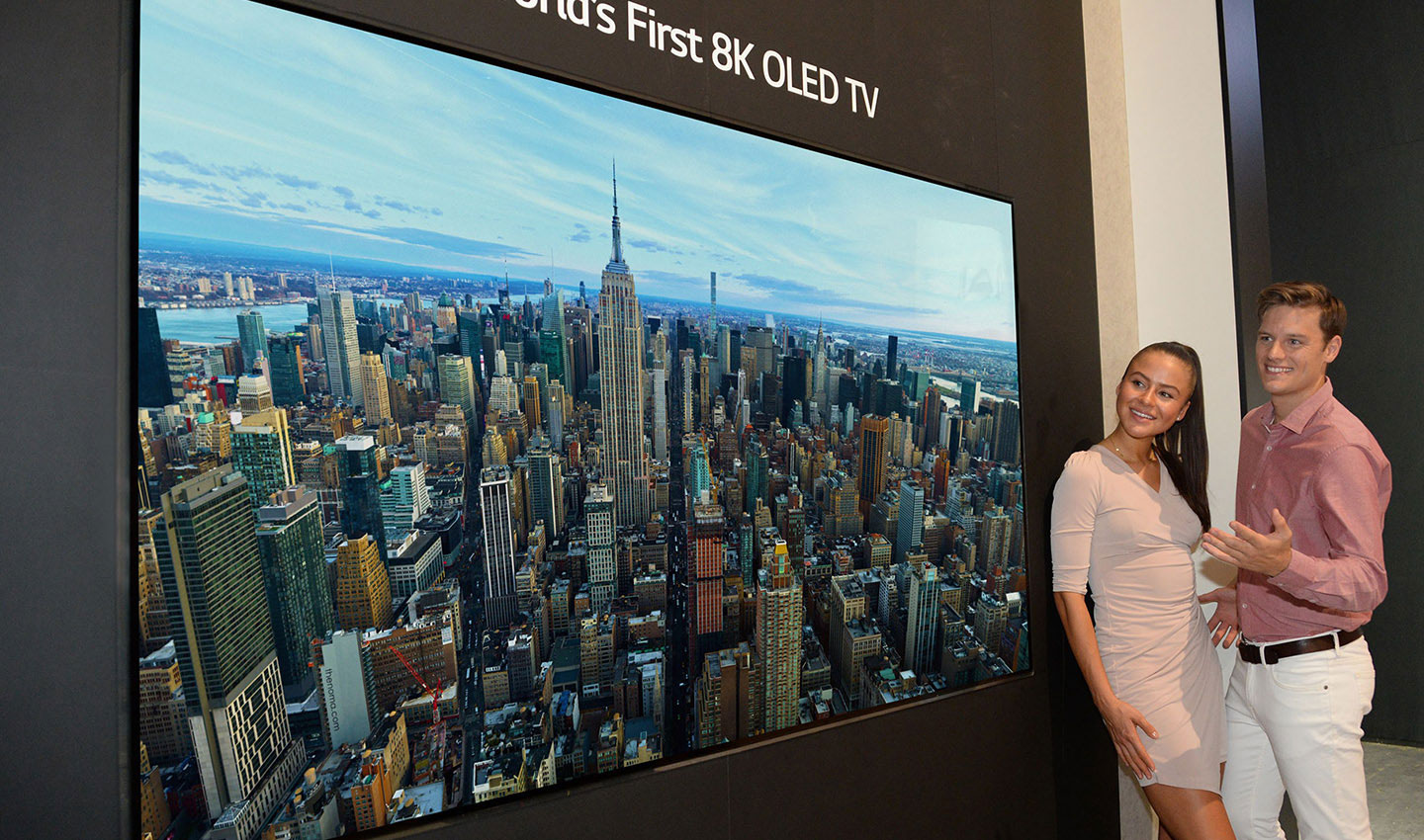 World’s First 8K OLED TV display at IFA 2018, with a male and female model standing on the right side