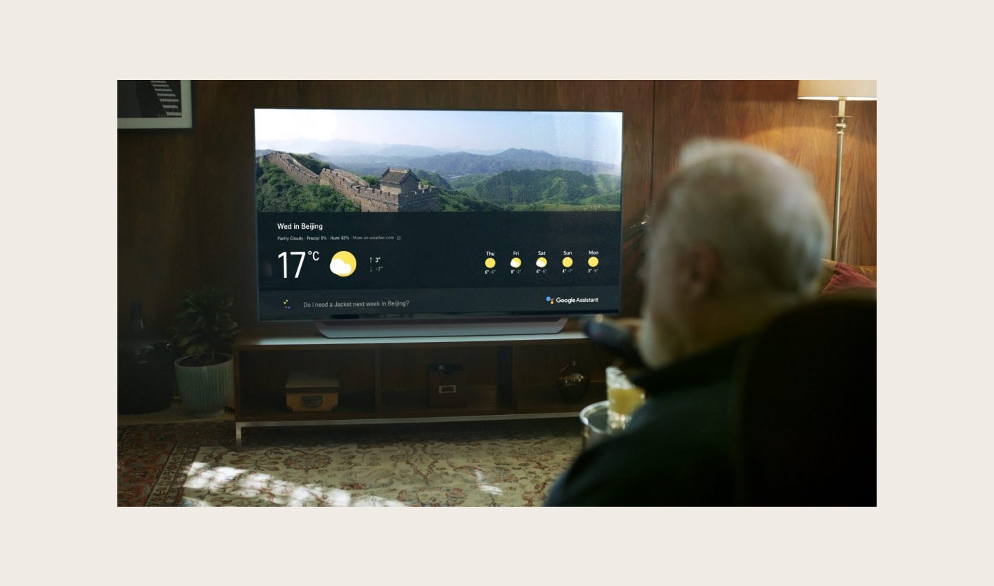 An old man asks LG's ThinQ-enabled TV for the weather forecast of Beijing for his travel.