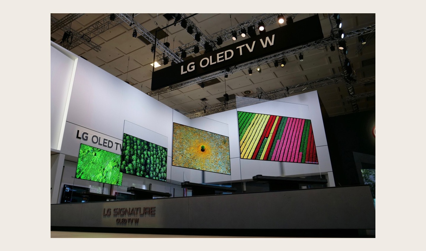 Four LG SIGNATURE OLED TV W sets placed side by side on a display stand rotate simultaneously.