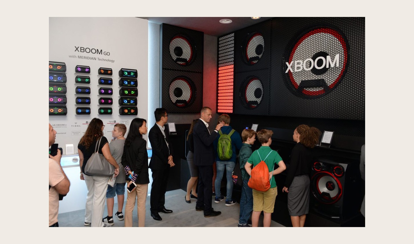 Visitors look at the products of LG XBOOM GO lineup which offers Meridian's premium sound.