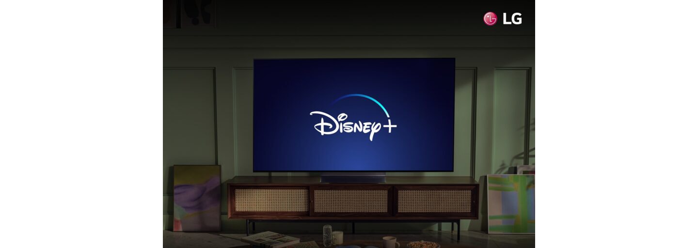 An LG TV in a living room displaying the Disney+ logo to celebrate the streaming service coming to more LG Smart TVs