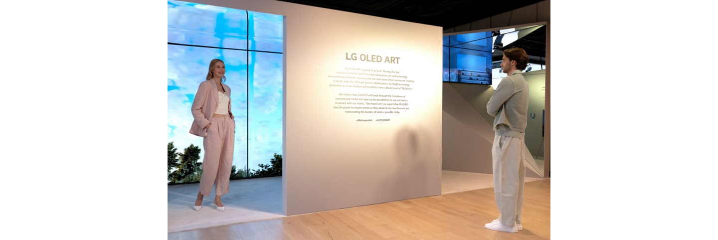 A man and a woman reading a description of the LG OLED Art exhibition on site