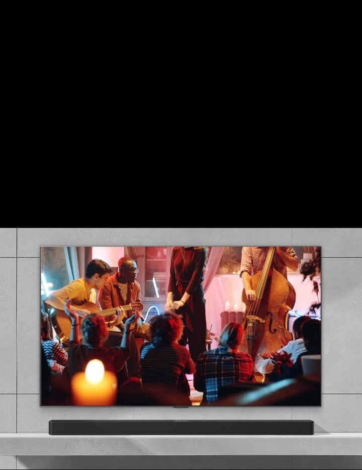 A cozy concert in a living room is playing on the screen. The WOW Interface menu appears as an overlay and the user navigates to soundbar settings with Magic Remote.