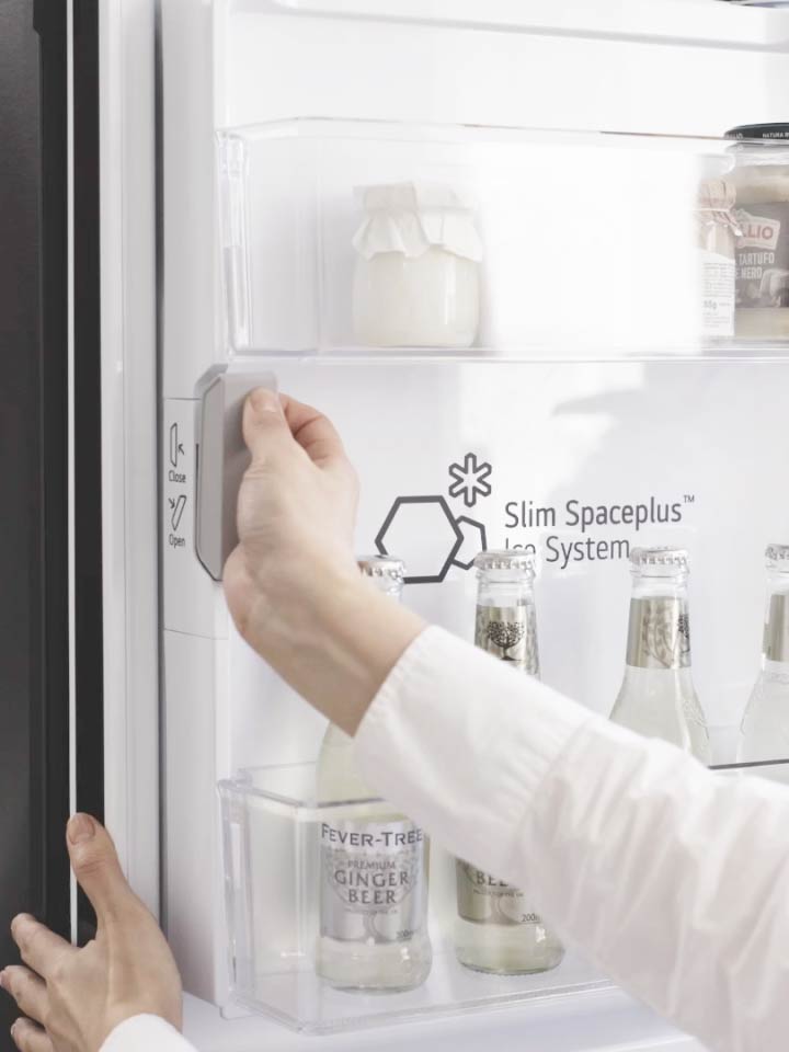 用家正打開 LG 雪櫃內的  Slim SpacePlus™ 製冰系統隔層