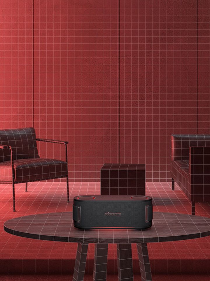 Furniture is placed in a space illuminated by red lighting, with an Xboom on the table in the center, scanning the surrounding space.