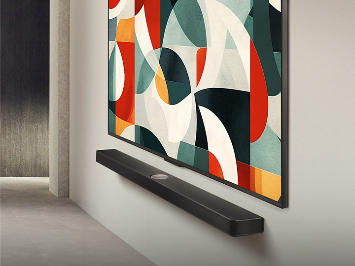 現代生活空間略為傾斜的側視圖,掛牆安裝的 LG QNED 電視置於 LG Soundbar 的上方,螢幕背景為綠、白、紅、橙色的抽象圖案。