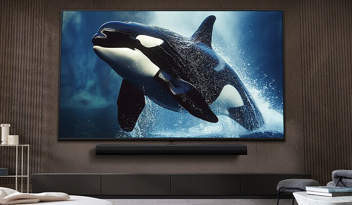 在時尚的客廳中,顯示一部掛牆安裝的 LG 電視,巨型螢幕之下則為 LG Soundbar。