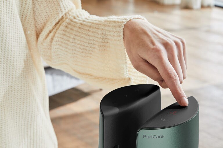 A woman is touching on the top of the product by her finger.