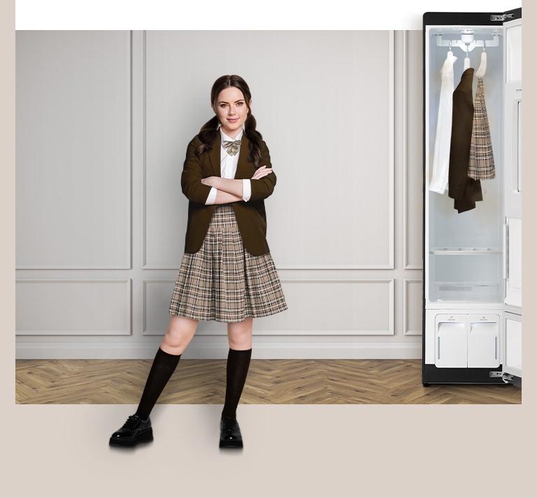 Student in uniform stands confidently beside an open LG wardrobe in a beige room, with clothes hanging inside.