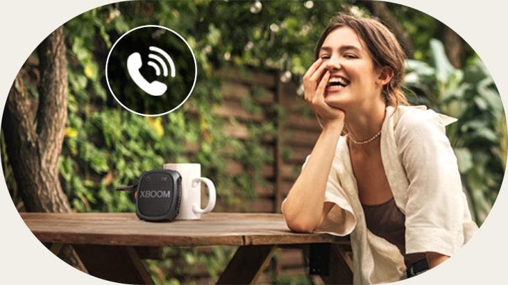 A woman is talking on the phone through LG XBOOM XG2T Speaker phone mode.