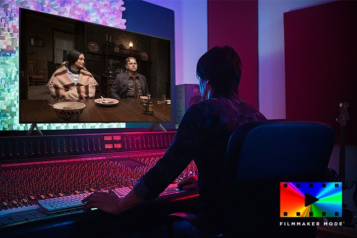 A director in front of a control panel editing the movie "Killers of the Flower Moon" on an LG QNED TV. In the bottom left, the Dolby Vision logo and FILMMAKER MODE logo.	