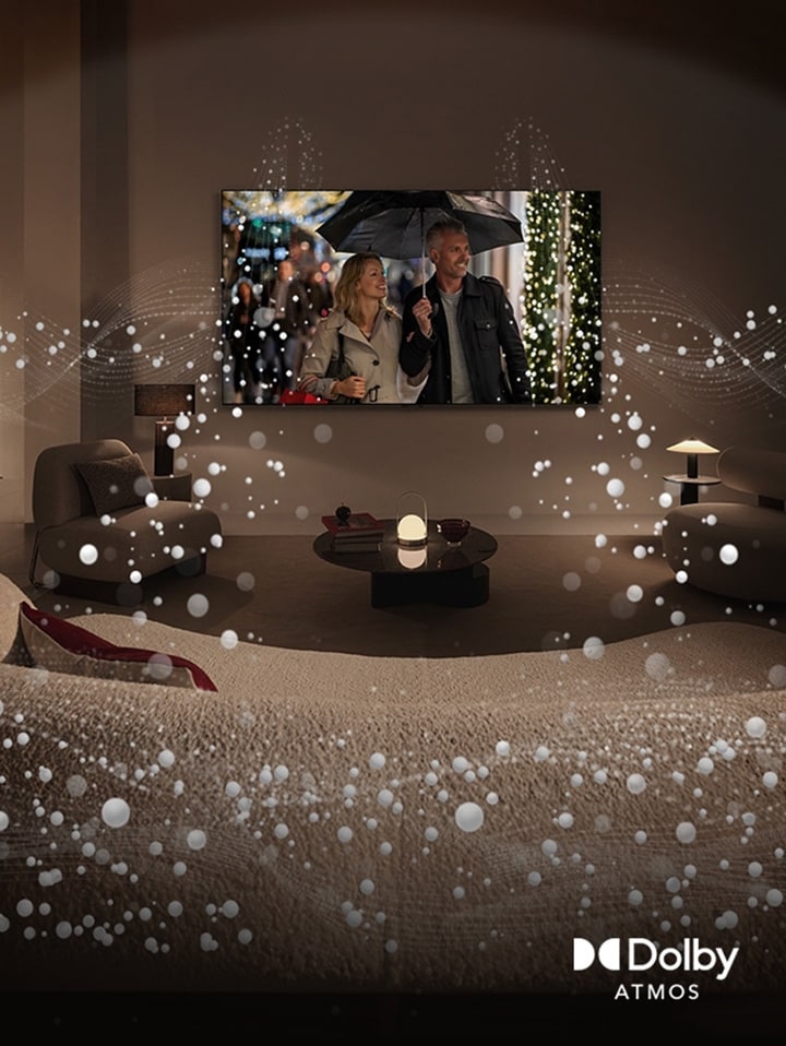 A cozy, dimly lit living space, LG OLED TV displaying a couple is using an umbrella, and bright circle graphics surround the room. Dolby Atoms logo in the bottom left corner.