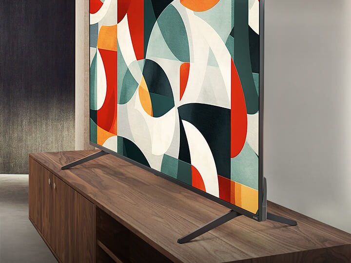 LG QNED TV berdiri di atas rak TV di ruang tamu modern. LG QNED TV menggambarkan latar belakang abstrak dalam warna hijau, merah dan oranye.