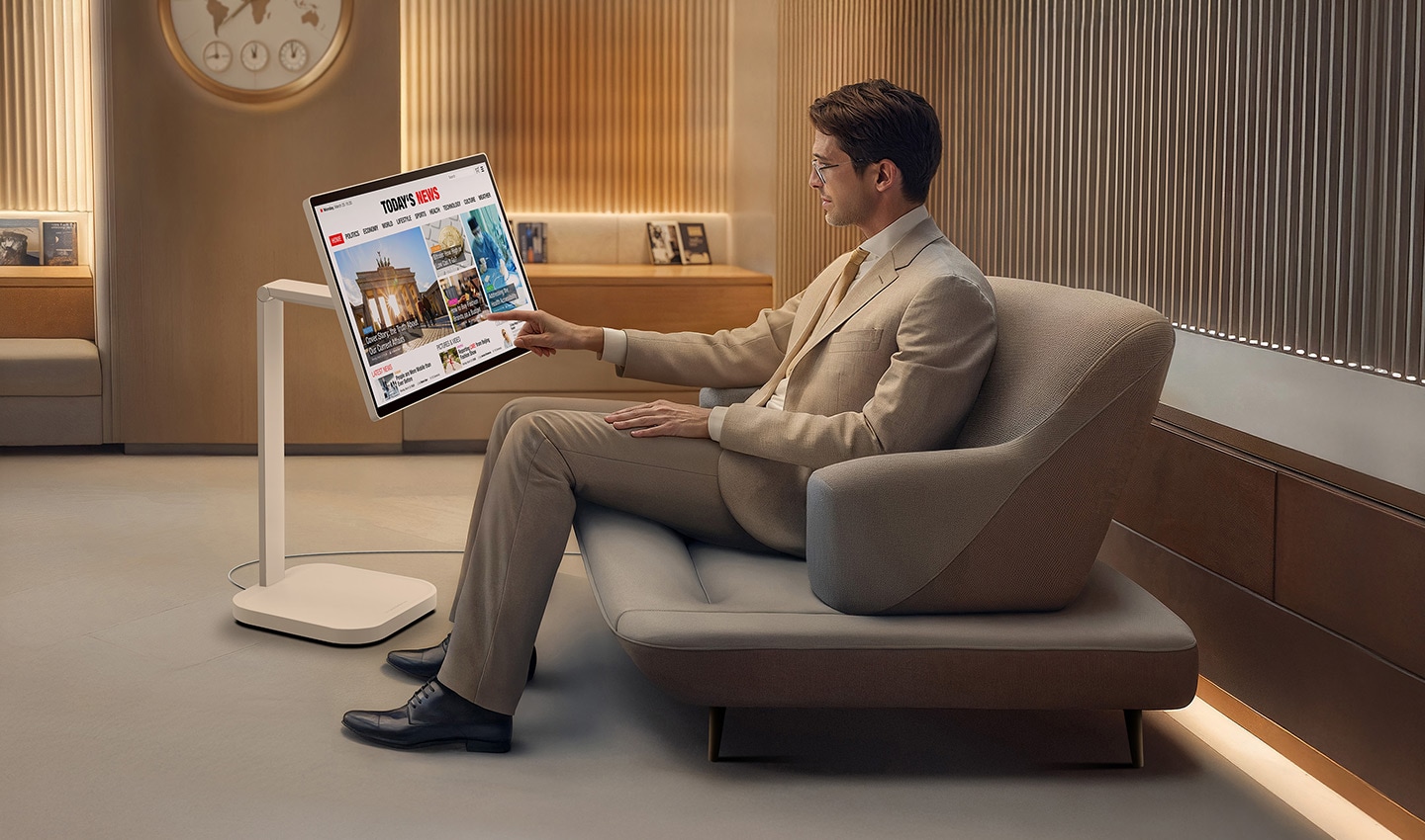 Seorang pria di ruang tunggu VIP sedang membaca berita di LG Smart Monitor Swing.
