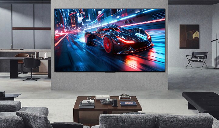 Living room with a huge LG Ultra Big TV mounted on the wall. On the screen is a car racing game. Because of the screen size, the content feels so much more immersive.