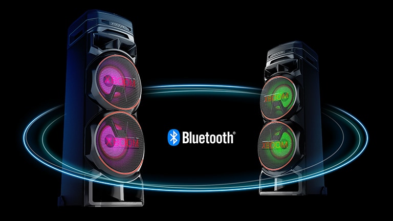 LG RNC9 Two RNC9s facing each other at diagonal angles against a black background with a Bluetooth logo in between. One has purple light on the woofer, and the other has green light.