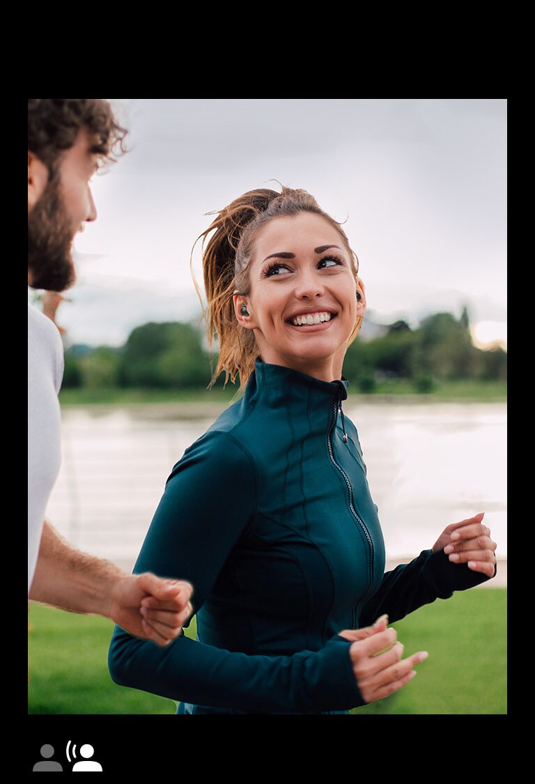 LG TONE-TF7Q A man and woman running in a park wearing TONE Free fit.