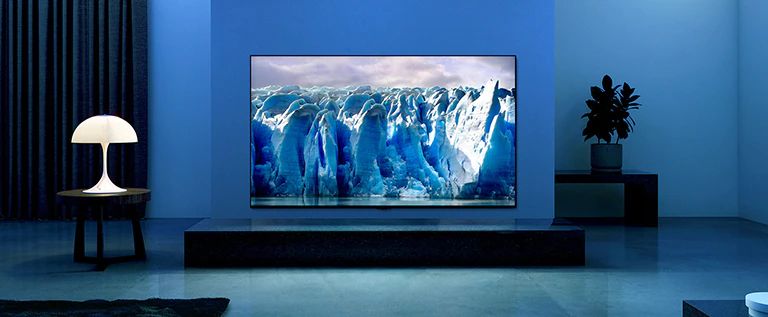 The video shows a close-up of iceberg image and there is a visual effect of blue circuit running on iceberg image. Scene changes to show a TV hanging on living room with blue lighting and background. There is a vast iceberg on TV screen.