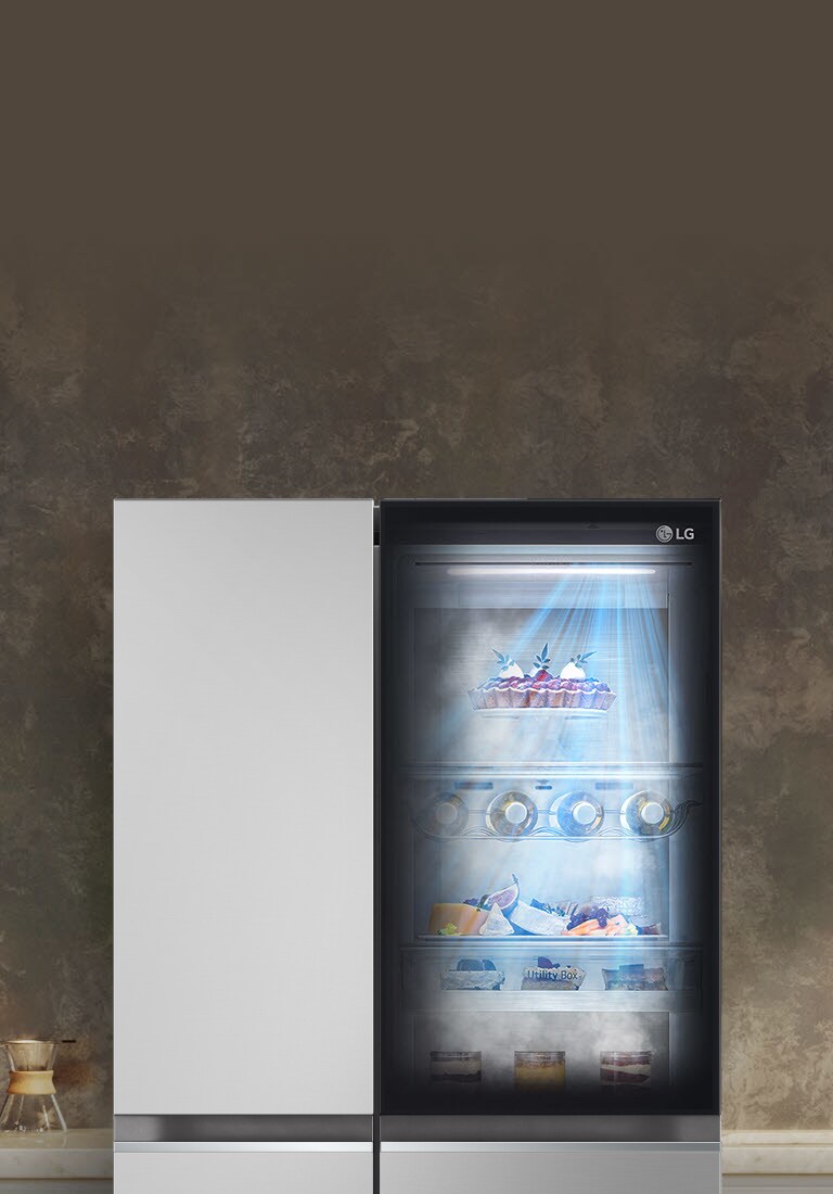 Frigorifero LG con porta in vetro illuminata, contenente dolci, bevande e cibi, in una cucina elegante e moderna.