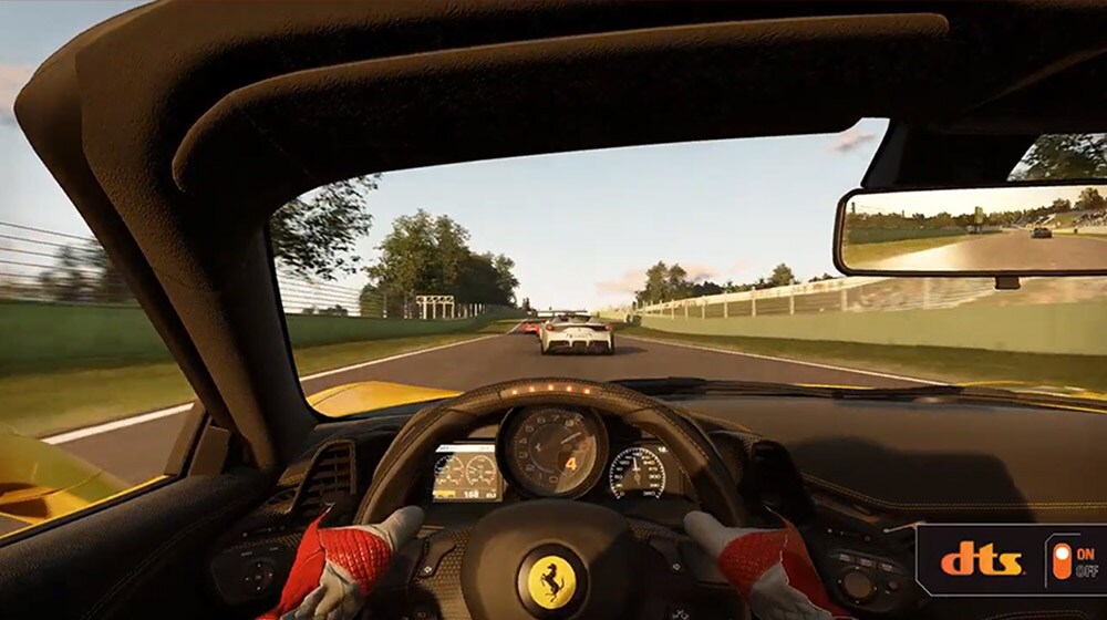 Video DTS di Project Cars 3 allegato. Schermata con la vista dalla prospettiva di un guidatore a bordo di una macchina da gara all’interno di un circuito; si vede il logo DTS nell’angolo inferiore destro dell’immagine.