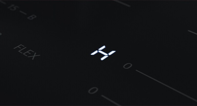 Dettaglio del led con la lettera &quot;H&quot; che indica che il piano cottura è ancora molto caldo.