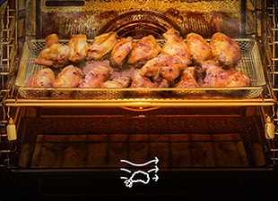  Ali di pollo arrosto dorate nel ripiano centrale di un forno ventilato con aria calda in circolazione visibile.