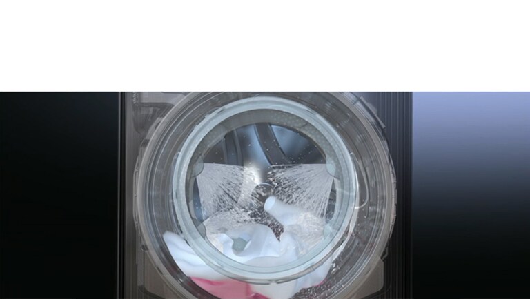 Immagine di un oblò della lavatrice in cui si vedono i getti di acqua che vengono spruzzati sui vestiti.