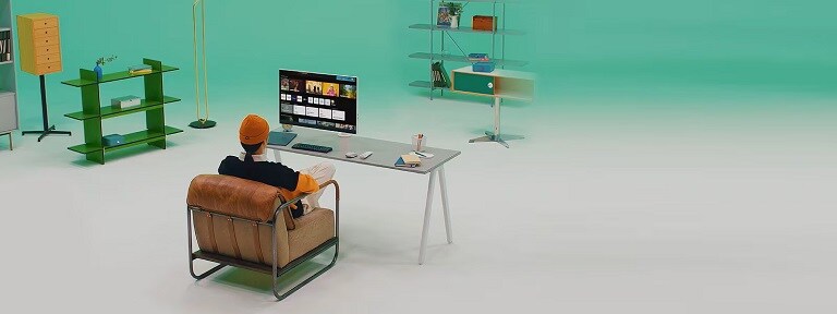 Una persona seduta a una scrivania minimalista in un ambiente moderno, che utilizza un monitor LG per navigare tra app e contenuti multimediali.