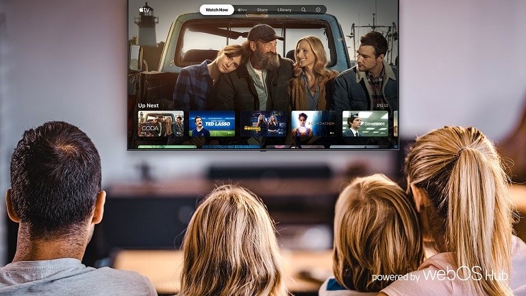 Famiglia seduta di fronte a una TV che mostra un'interfaccia di contenuti in streaming, con programmi disponibili su una piattaforma webOS.