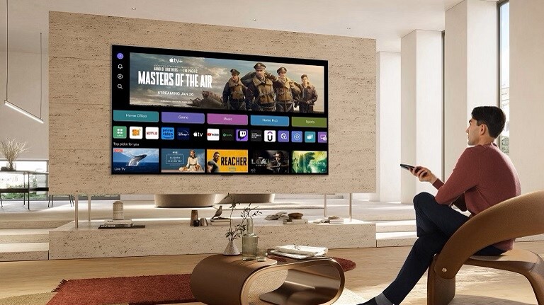 Un uomo che si gode il suo smart TV LG con IA, dotato di un’interfaccia user friendly e diverse opzioni di streaming, all’interno di un soggiorno moderno.