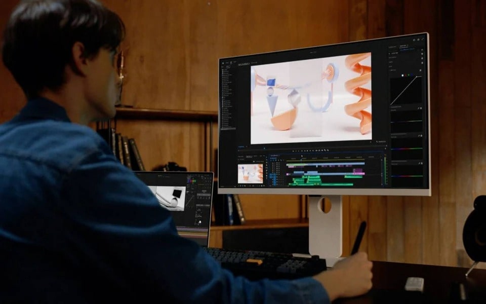 Uno smart monitor LG usato per il video editing in una postazione compatta e ben organizzata. La scrivania è in ordine, mentre sul monitor è visualizzato un software di editing dall’interfaccia semplice. La scena enfatizza l’uso efficiente dello spazio in una postazione di lavoro accogliente con decorazioni in legno.