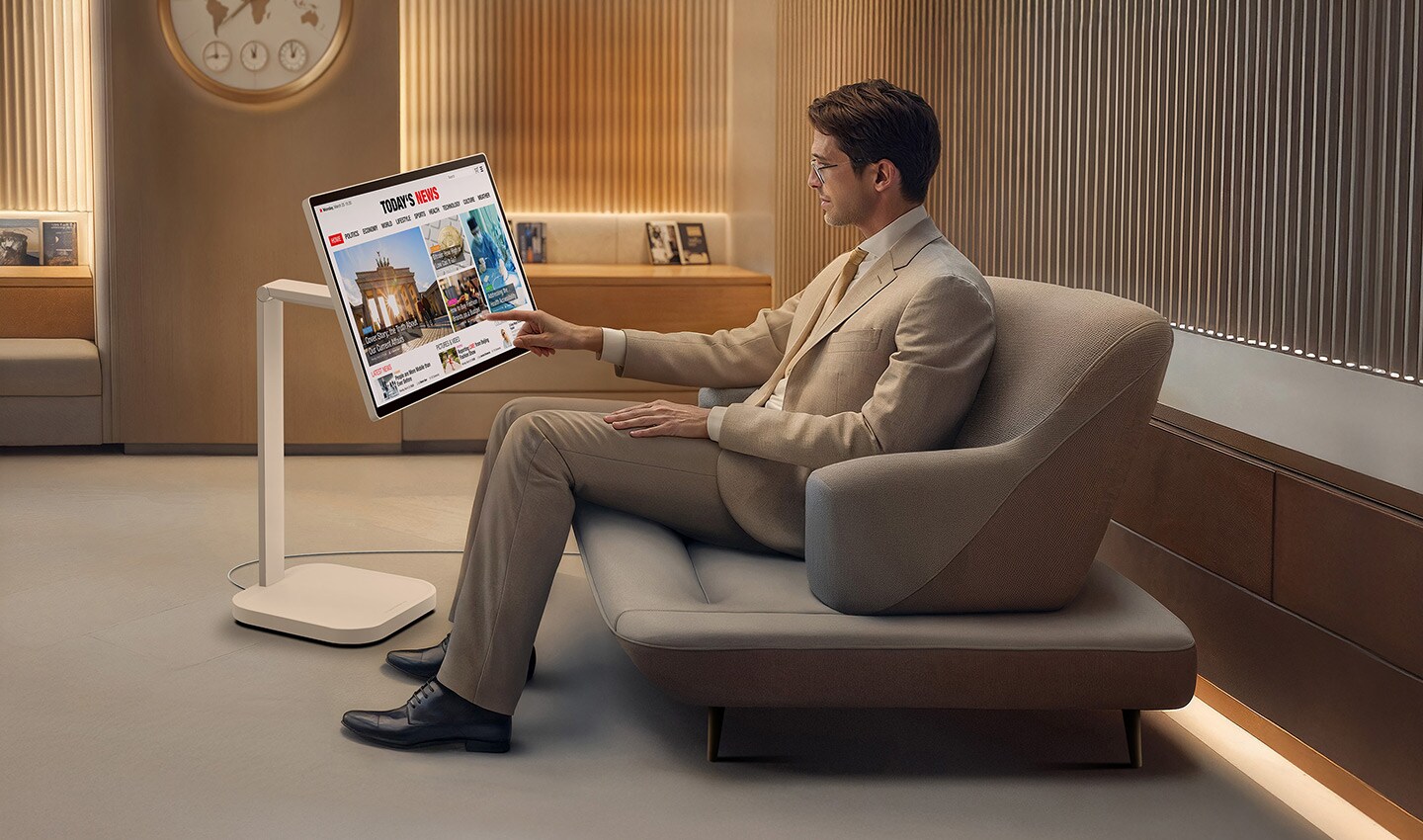 A man in the VIP lounge is reading the news on a LG Smart Monitor Swing.