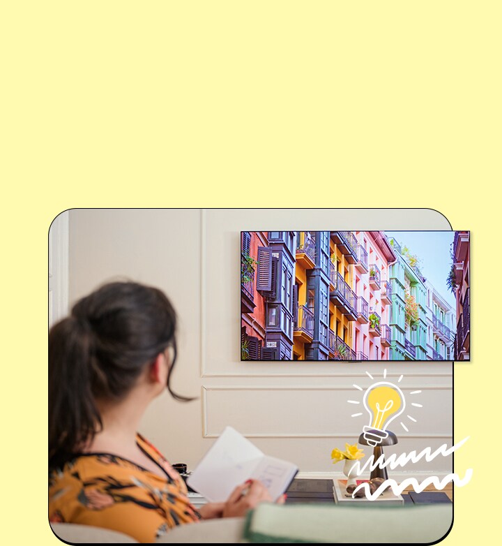 La donna guarda la televisione con un notebook.