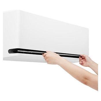 Hands opening the lower vane of an LG air conditioner for cleaning or maintenance