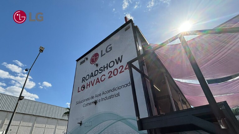 Camión de LG con letrero 'LG HVAC 2024 Roadshow' bajo el sol, mostrando soluciones de aire acondicionado comercial e industrial.