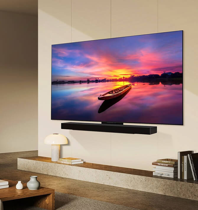 Sala de estar con LG OLED TV en la pared con repisa, libro y plantas