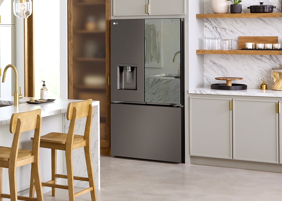 Cocina espaciosa con el refrigerador LG GM89SXD y una elegante isla de mármol, rodeada de gabinetes grises con detalles en madera.