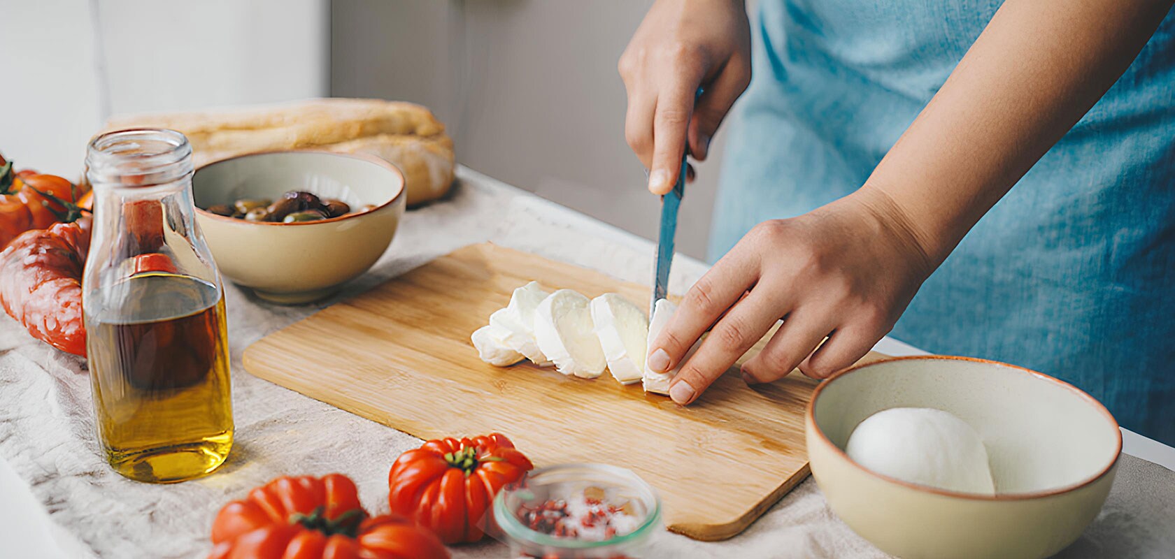 Primer plano de manos preparando comida fresca en un ambiente acogedor de cocina.