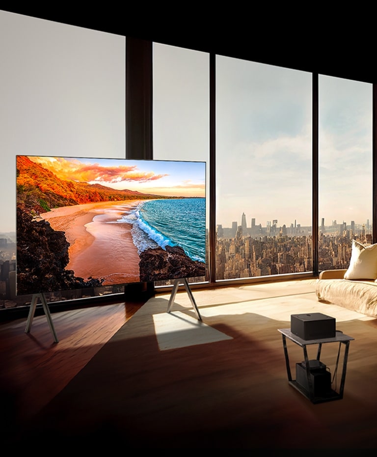 LG SIGNATURE OLED M4 en un soporte frente a ventanas del piso al techo en un apartamento moderno y soleado.