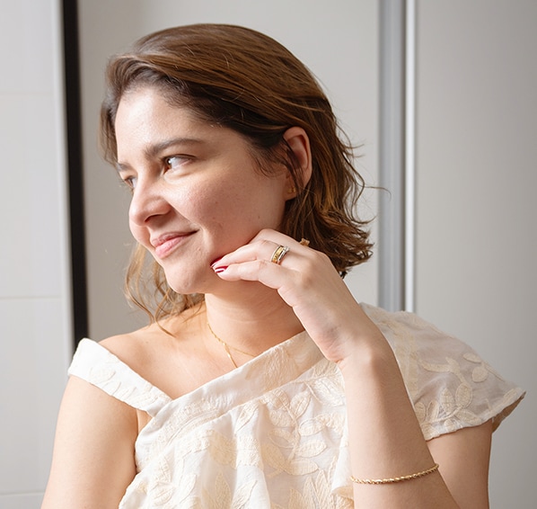 Una foto biográfica de madre con pelo castaño y camisas blancas, posando como un editor especial de los contenidos.