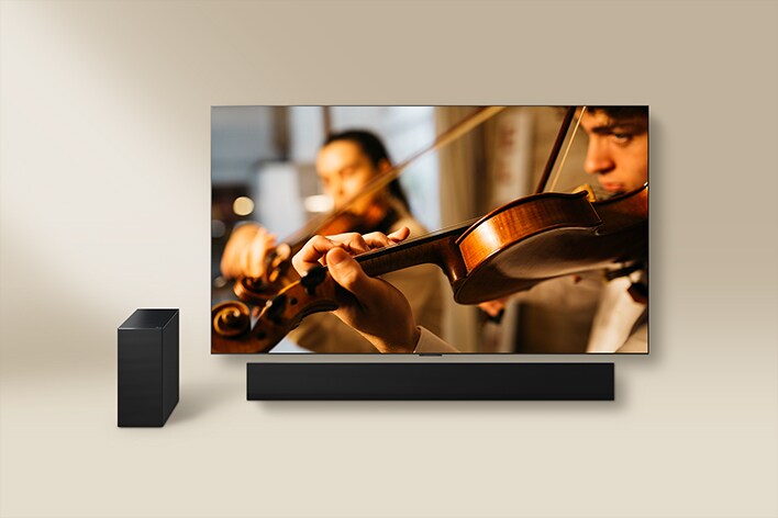 LG TV seen together with an LG Soundbar and external speaker. On the screen is a violinist performing.
