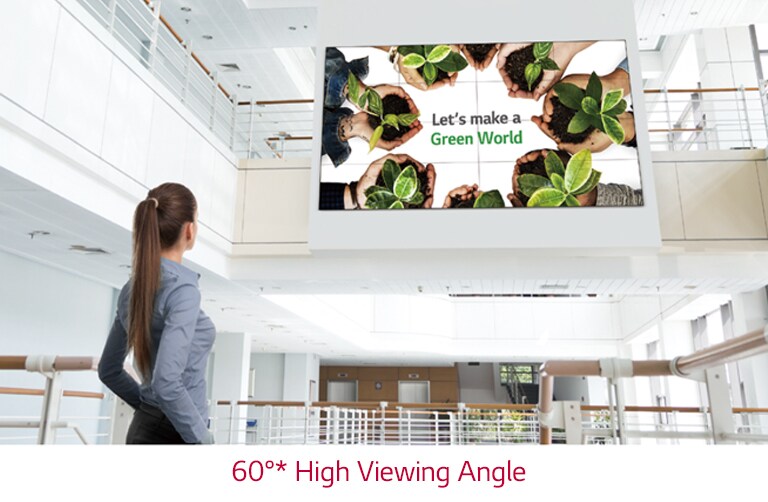 A woman is looking up at the screen installed upstairs.