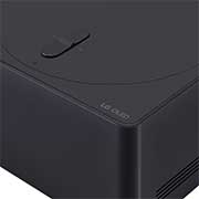 Een LG OLED evo M4 gemonteerd op een gemarmerde muur van een heldere, moderne huiskamer. Een Zero Connect Box op een tafel achter andere meubels, en een rood wifisignaal en rode straal die naar de tv gaat. De woorden “location FREE” (locatie-onafhankelijk) verschijnen in de hoek linksonder.