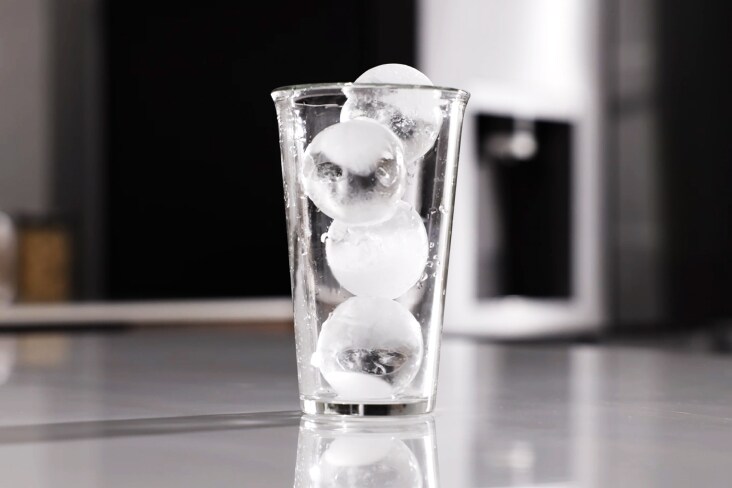 Helder glas gevuld met ronde craft ice-ballen uit een LG-koelkast