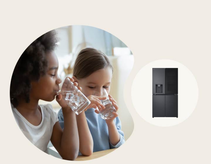 Twee kinderen drinken water aan een tafel met een LG-koelkast en ingebouwde dispenser op de achtergrond