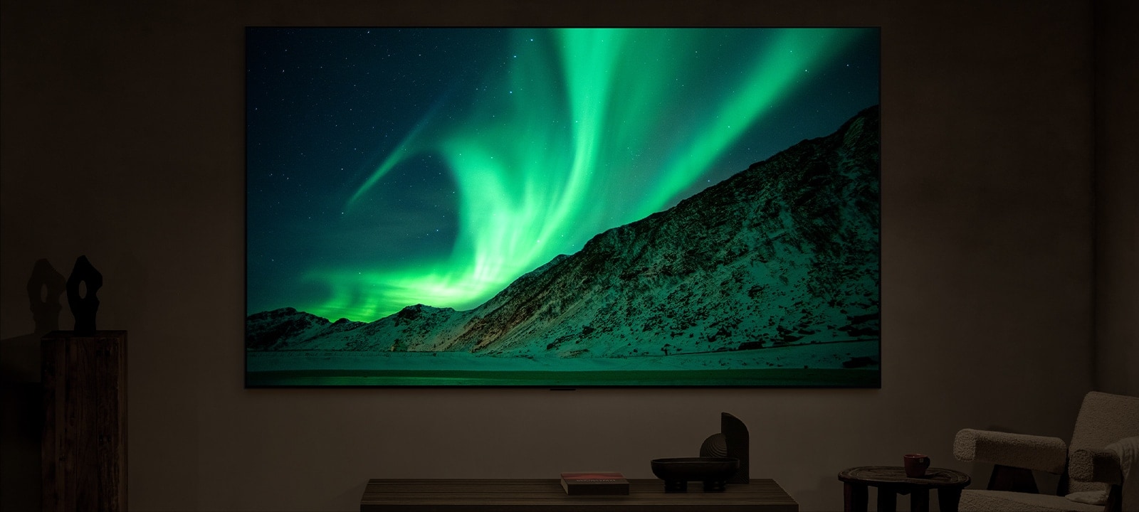 Een LG TV in een moderne woonkamer in de avond. Op het label staat: ’s nachts. AI Brightness Control zorgt ervoor dat het beeld van het noorderlicht op de TV wordt weergegeven met het perfecte helderheidsniveau voor het licht in de kamer.