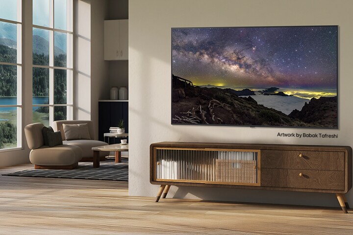 Interieur van een landelijk huis. Een grote, aan de muur gemonteerde LG TV toont een prachtig kunstwerk van een natuurlijk landschap op het scherm. De TV lijkt op een foto die aan de muur hangt. 