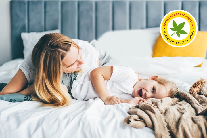 Het kind en de moeder liggen op het bed.	