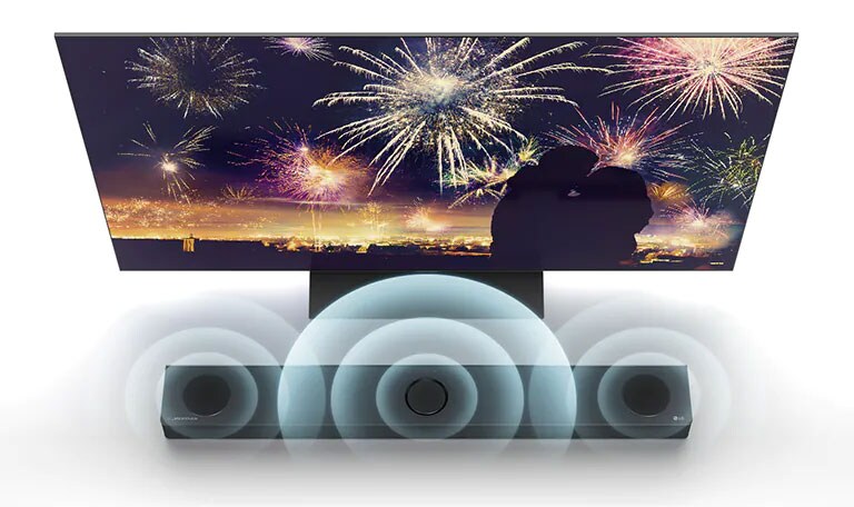 In vogelvluchtperspectief staat de LG TV op de vloer en de LG soundbar staat recht onder de tv in de oneindige ruimte. Op het scherm, een silhouet van een koppel op de achtergrond van vuurwerk. Soundwave-beelden komen uit de middelste, linker en rechter luidspreker bovenaan de soundbar.