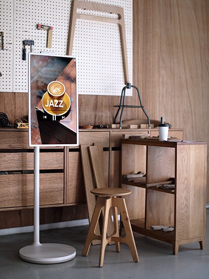 StanbyME wordt in het midden van een meubelatelier geplaatst en het tv-scherm toont de cover van een Jazz muziekalbum.